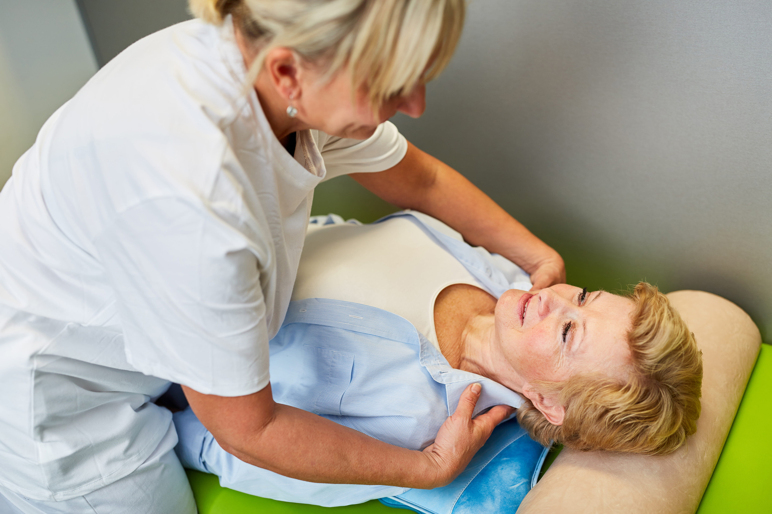 Naturopathic practitioner providing hands-on neck and cervical treatment to a woman on a therapy table, representing holistic perimenopause care including acupuncture and manual therapy at the Adelaide Health Clinic